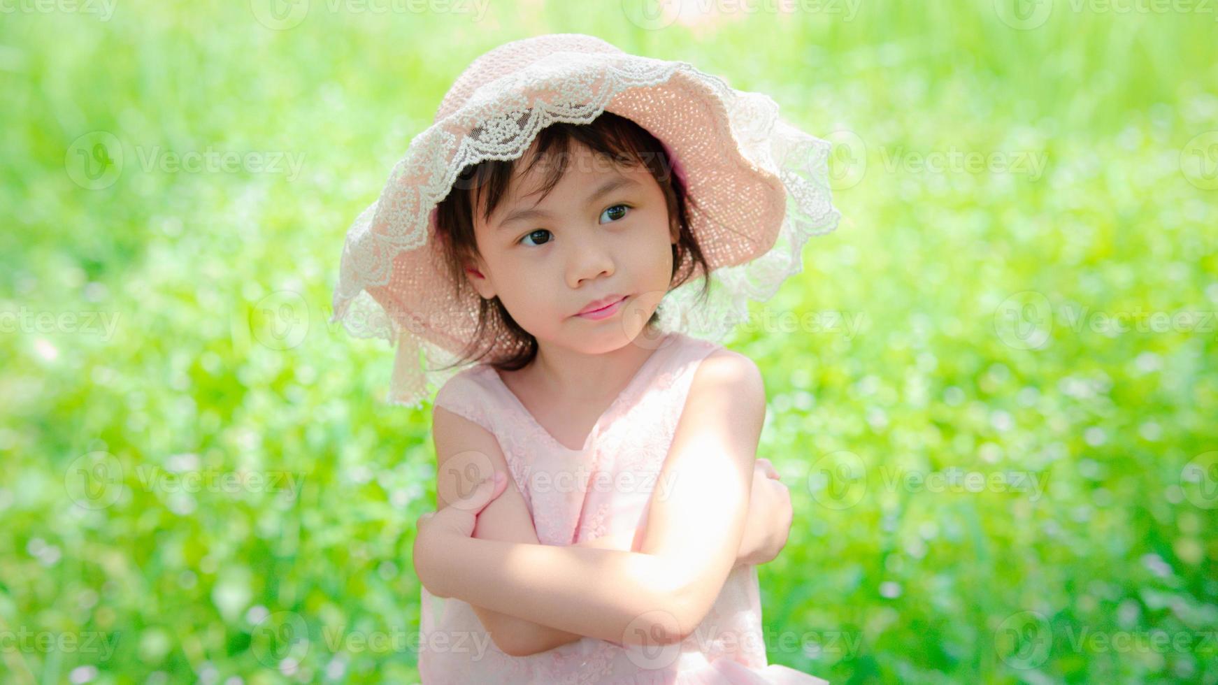 positiva encantadora niña asiática de 4 años de edad, pequeña niña preescolar con adorable cabello corto sonriendo y mirando a la derecha. copie el espacio foto