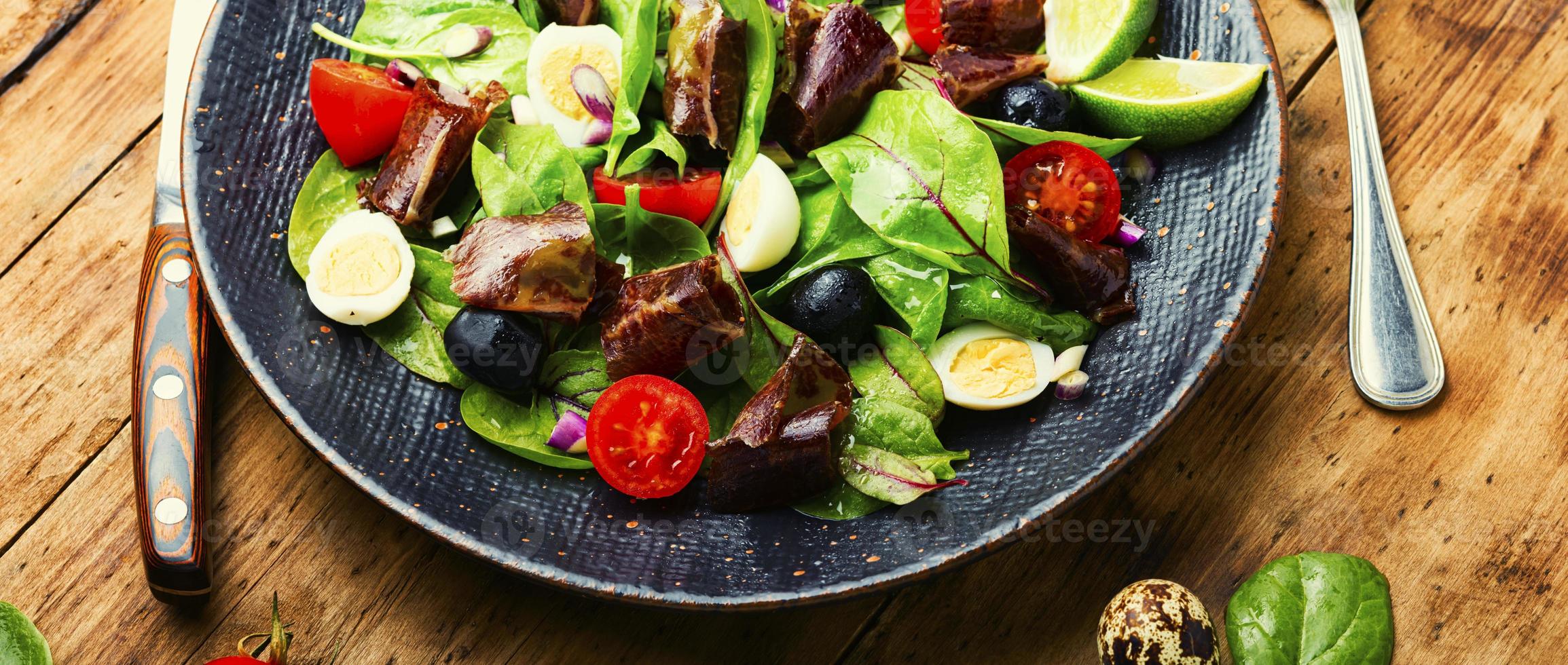 Delicious salad with vegetables, herbs and ham photo