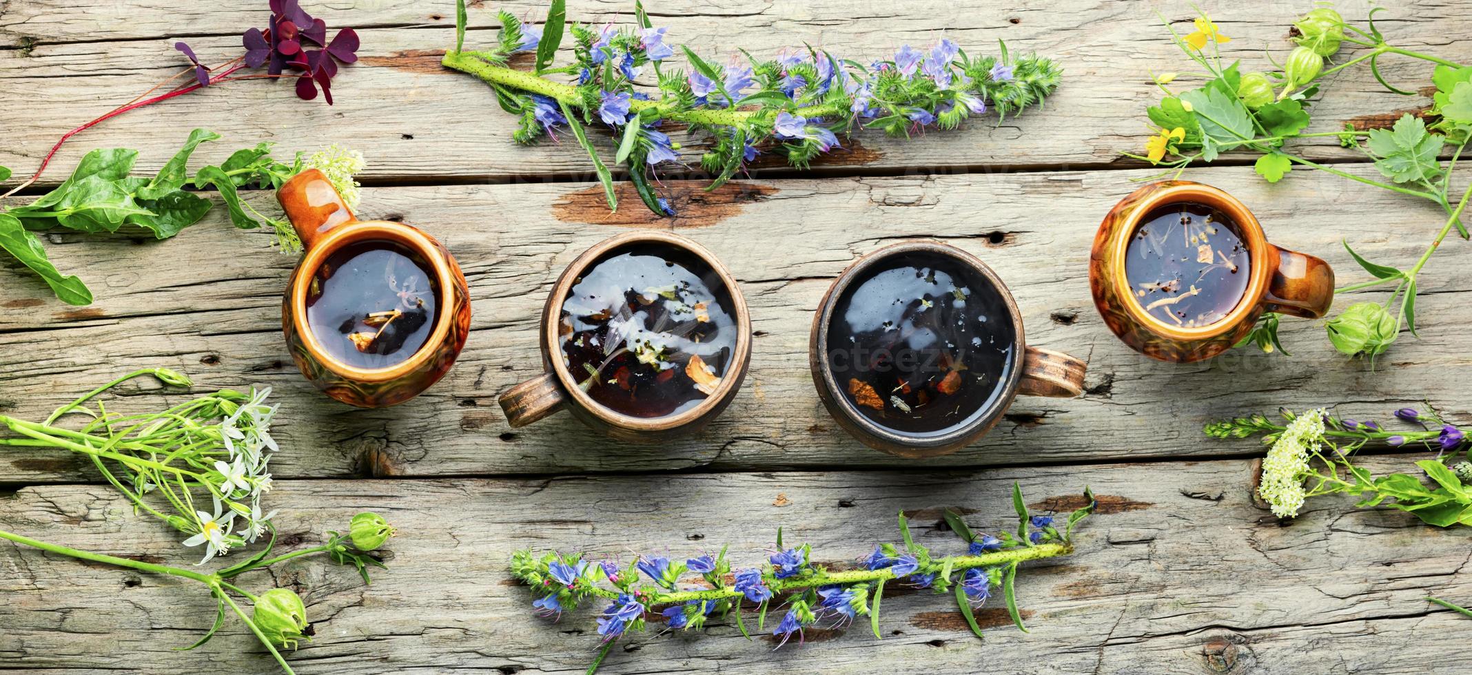 Mugs of herbal tea with various herbs photo