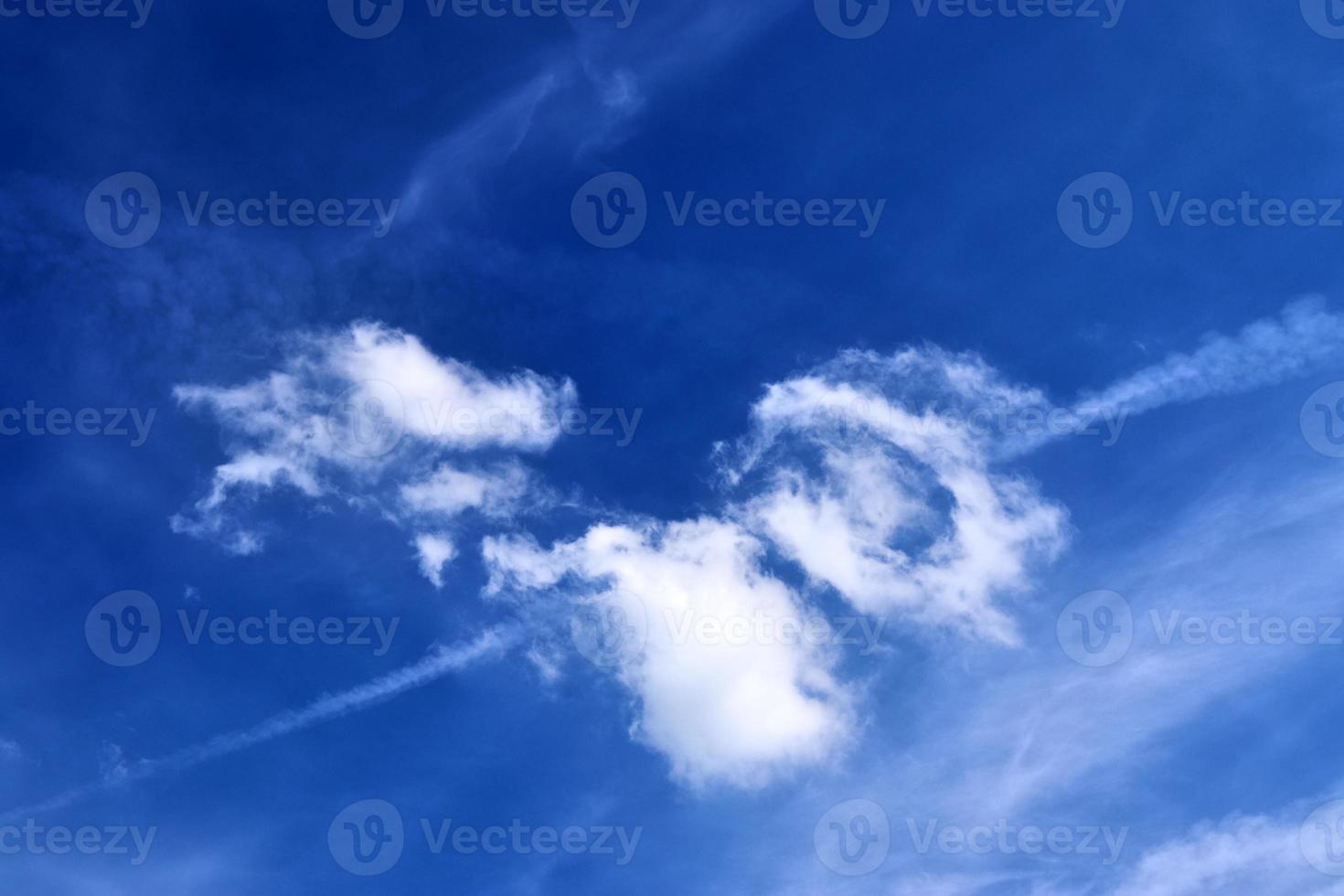 Beautiful fluffy white cloud formations in a deep blue summer sky photo