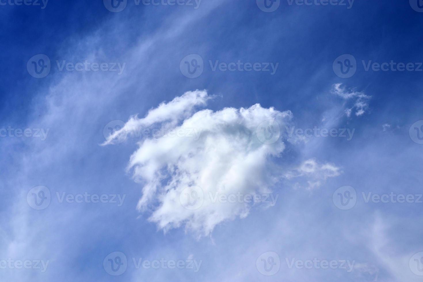 Beautiful fluffy white cloud formations in a deep blue summer sky photo