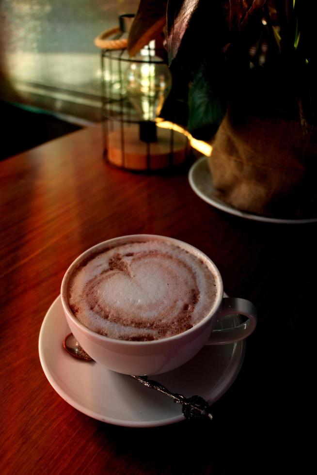 cup of hot coffee on wooden table photo