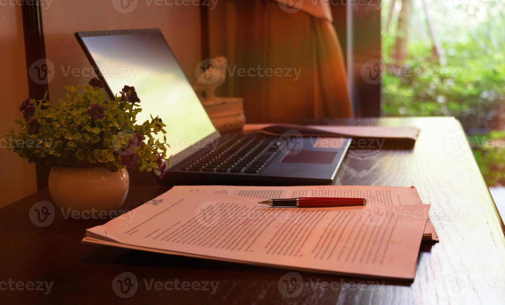 red pen over blurred paperwork on wooden table photo