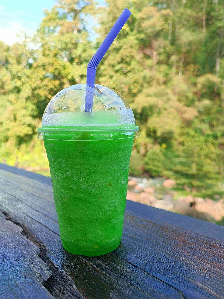 glass of fresh smoothie green apple on wooden table photo