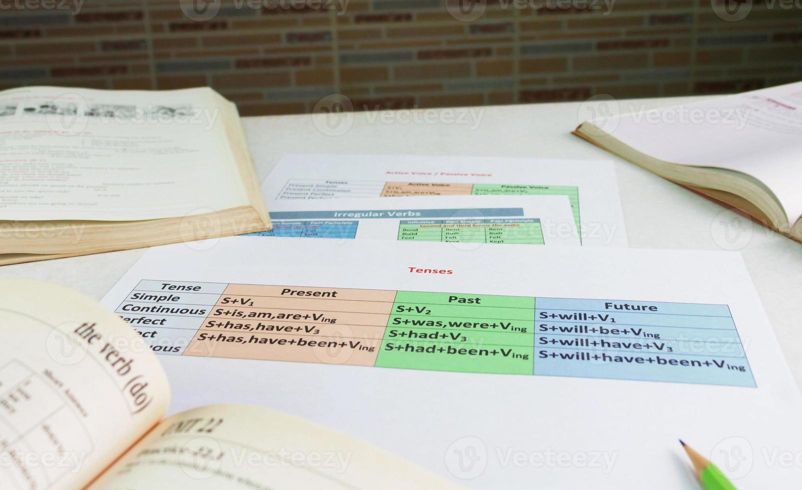 colorful English grammar sheets on white table photo