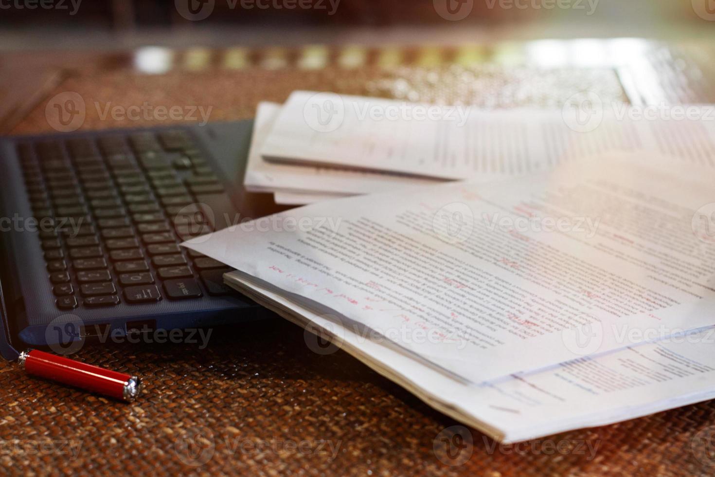 blurred paperwork over laptop on table in office photo