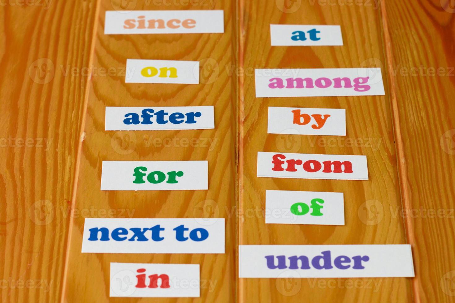 coloridas tarjetas de preposición inglesa sobre una mesa de madera foto