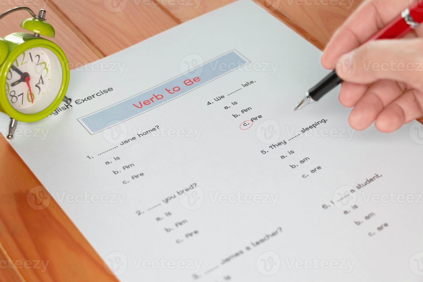 English grammar test sheet on wooden table photo