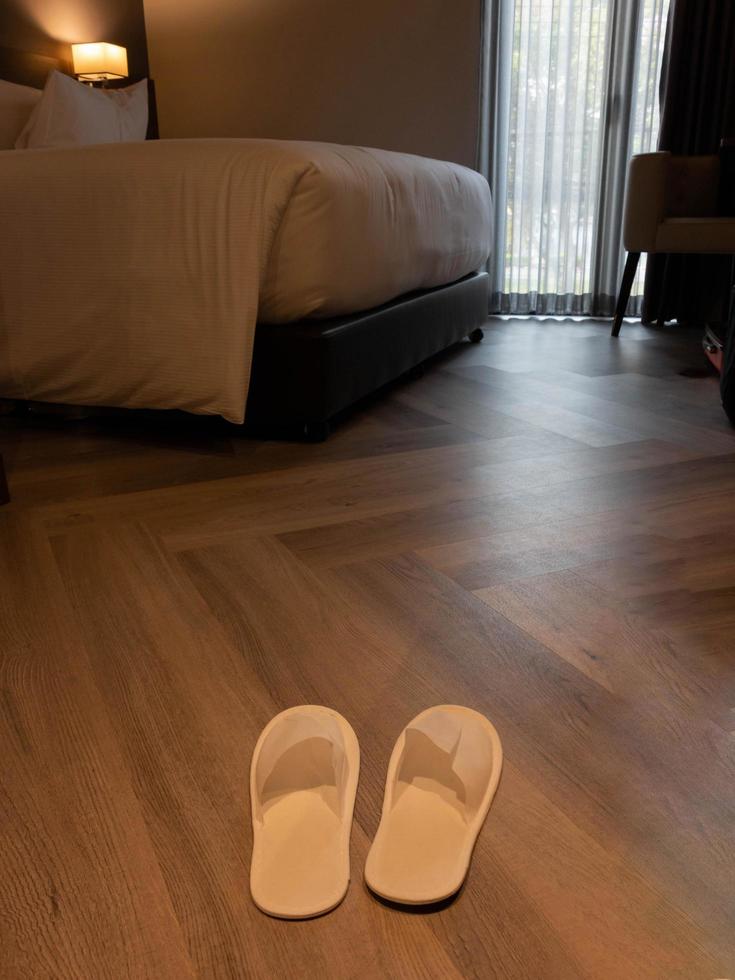 brand new white slippers on floor in hotel photo