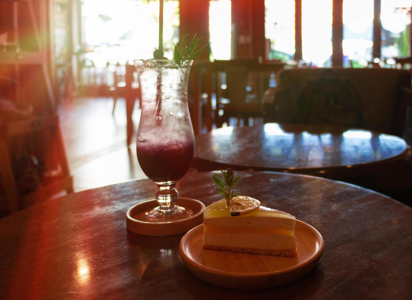 cold blueberry soda and lemon cake on wooden table photo