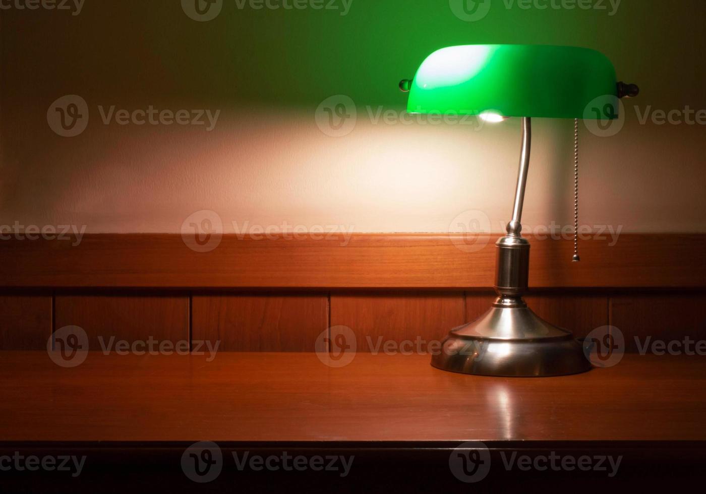 vintage lamp with green shade on wooden desk photo