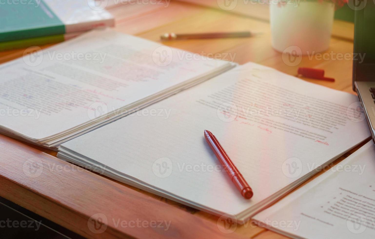 red pen on blurred paperwork and books photo