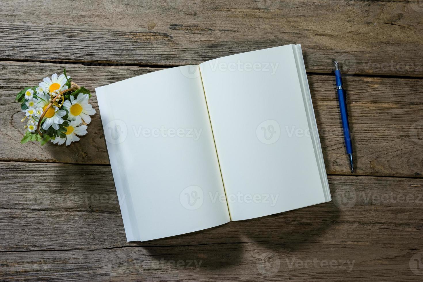 open note book with clutch-type pencil on wood background photo