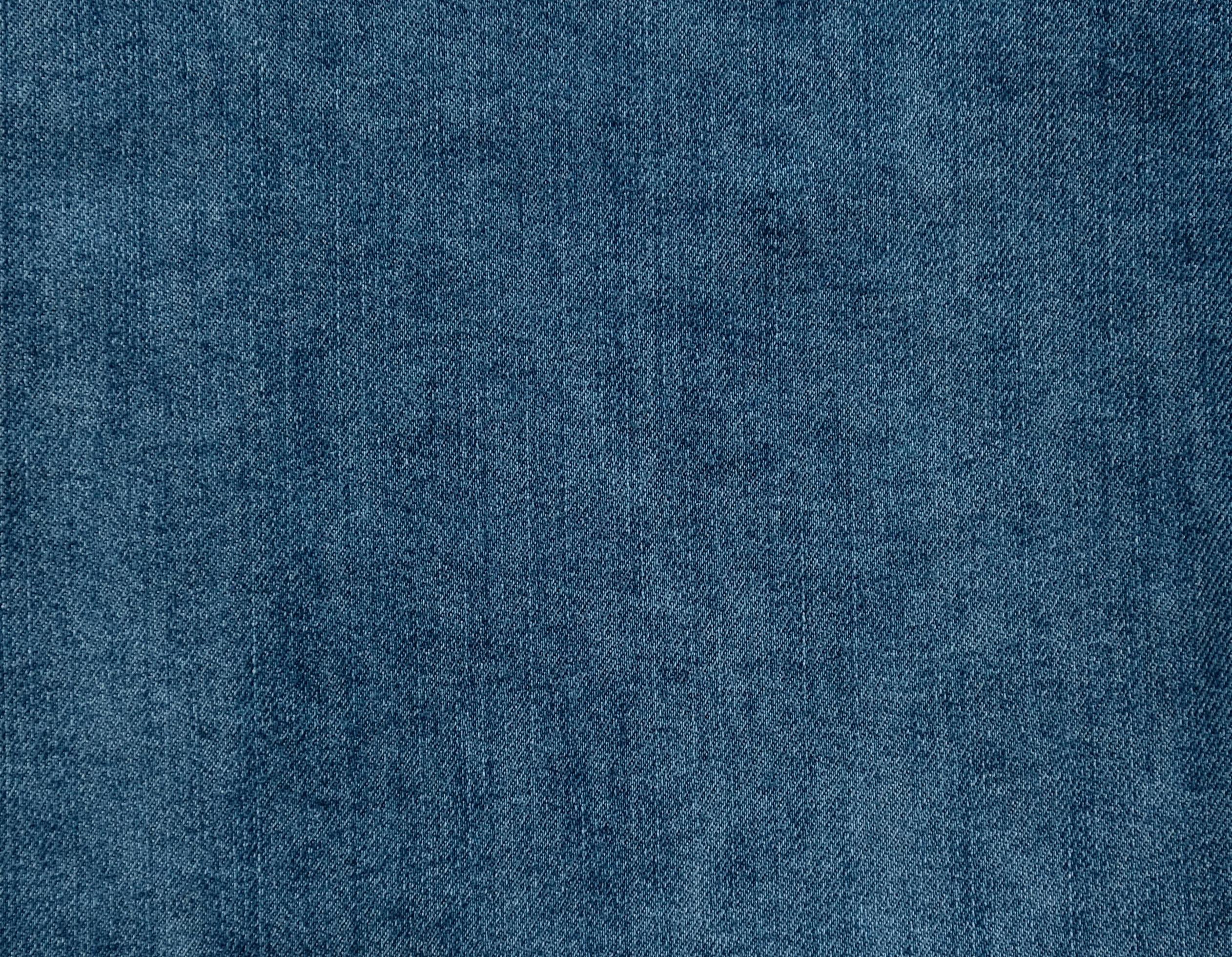 Blue denim jeans textile background. Faded blue jeans. Denim fabric