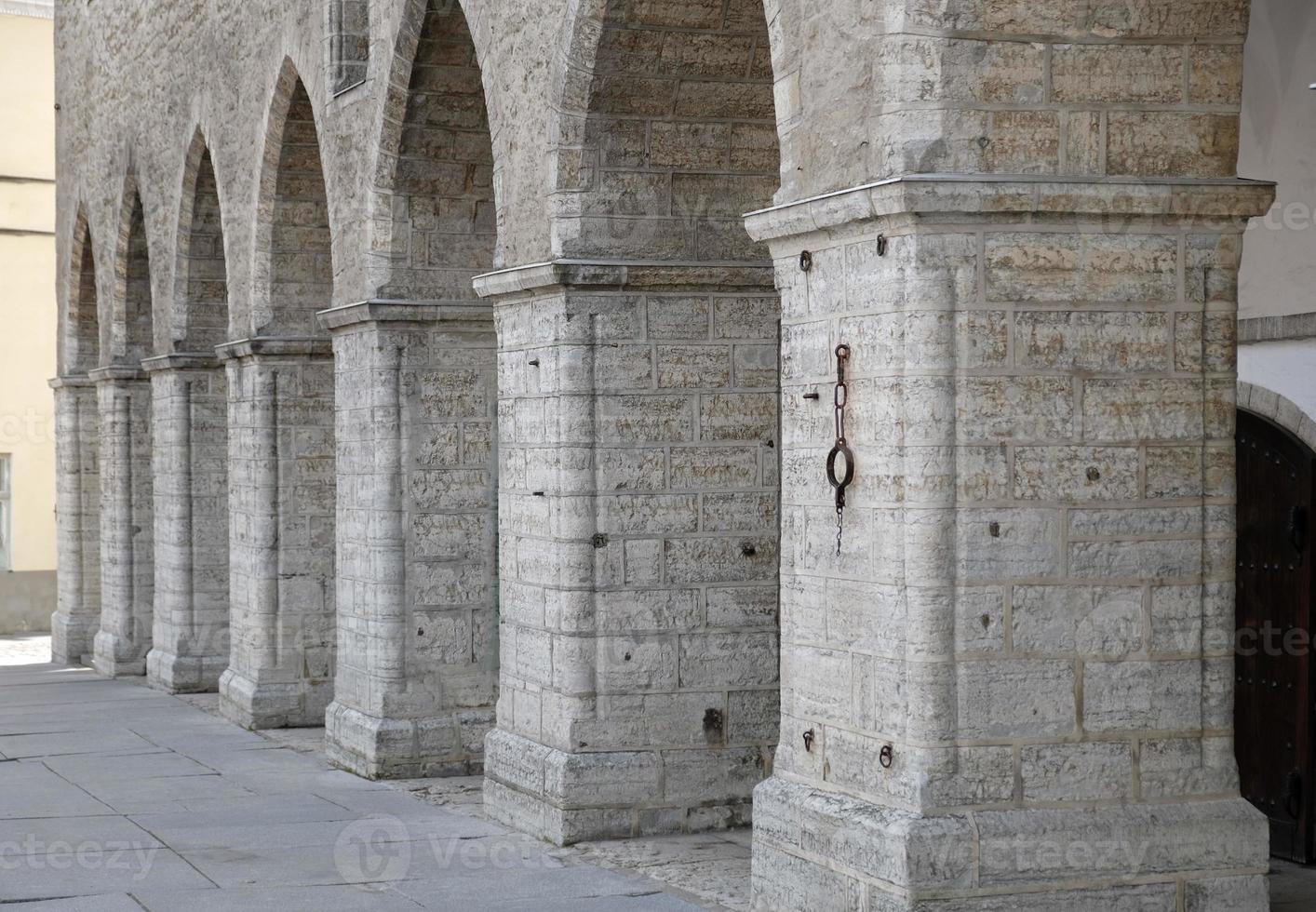 Classic architectural column and arch. Details of architecture of medieval building. Element of exterior building with columns and arches of old town hall in central square of Old Tallinn, Estonia. photo