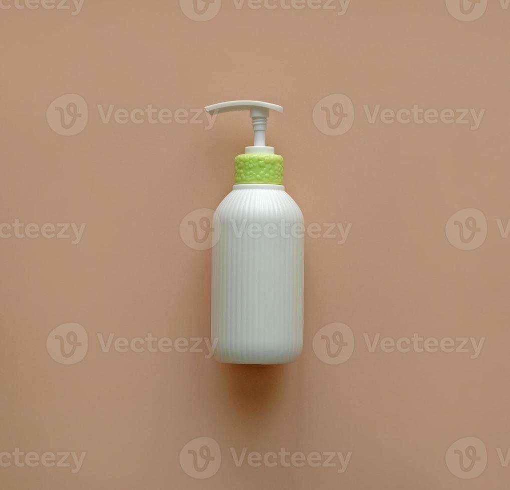 White corrugated bottle surface soap dispenser pump. Skin care Lotion. Bathing essential product. Shampoo bottle. Mock-up pump bottle of moisturizing lotion, soap, or sanitizer on beige background. photo
