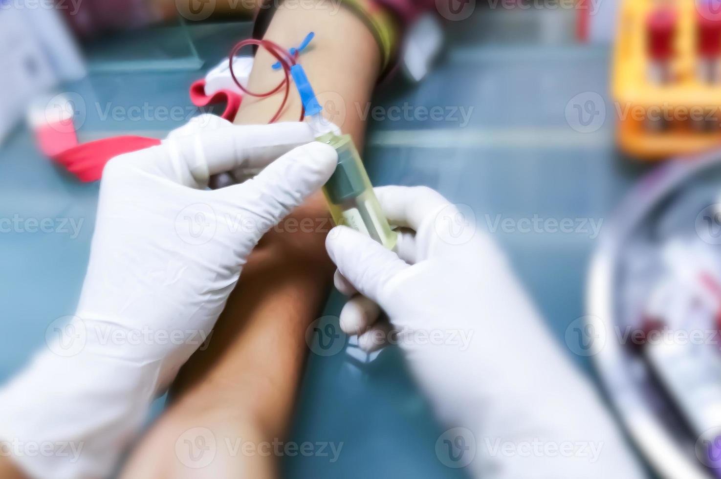 Phlebotomist detecting median cubital vein or cephalic vein to place needle for collecting blood in hospital. photo