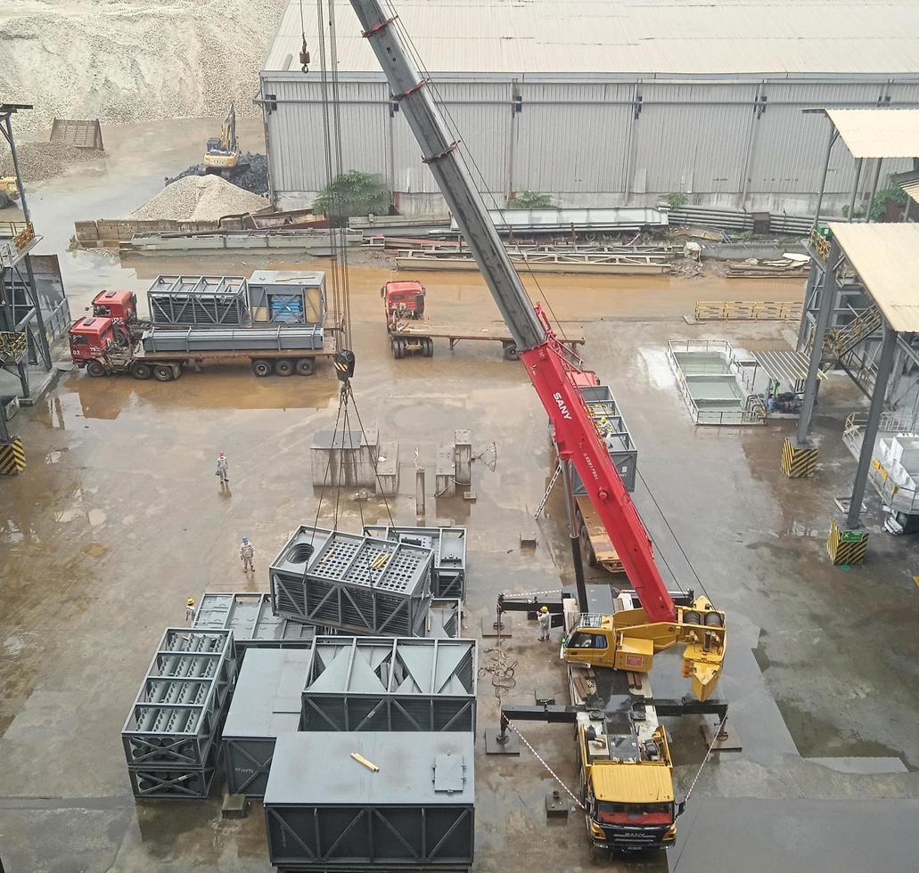 una grúa levanta una caja de metal para la construcción de una fábrica foto