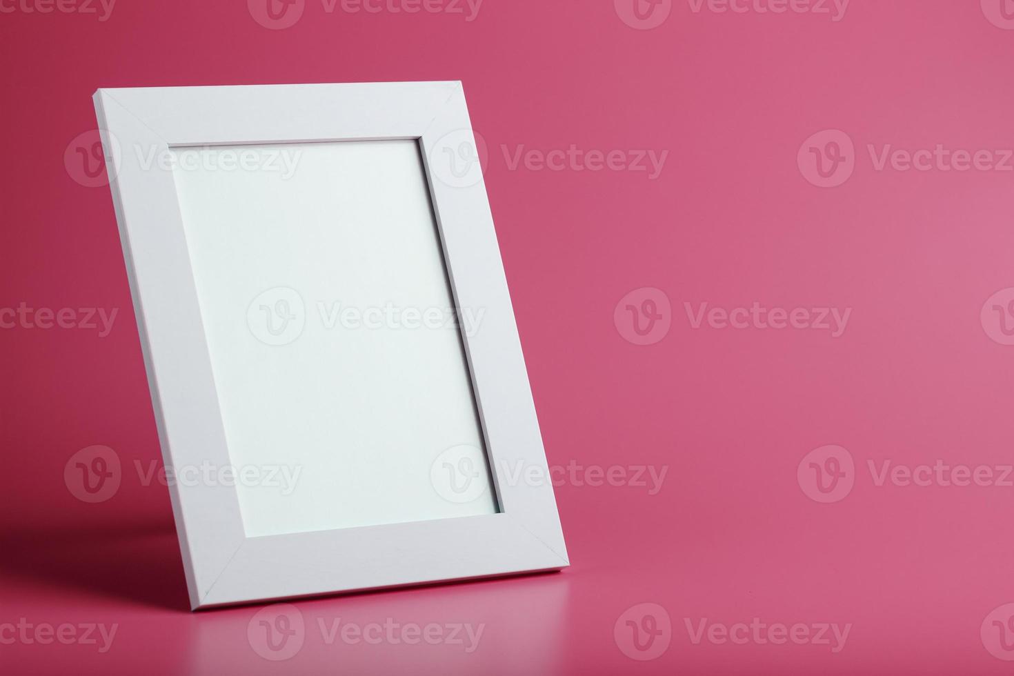 White photo frame with an empty space on a pink background.