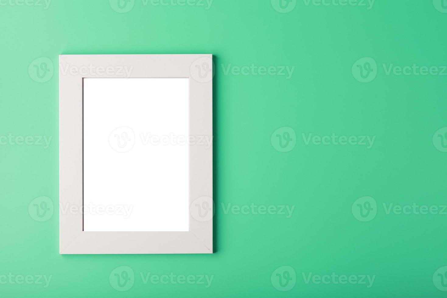 marco de fotos blanco con un espacio vacío sobre un fondo verde.