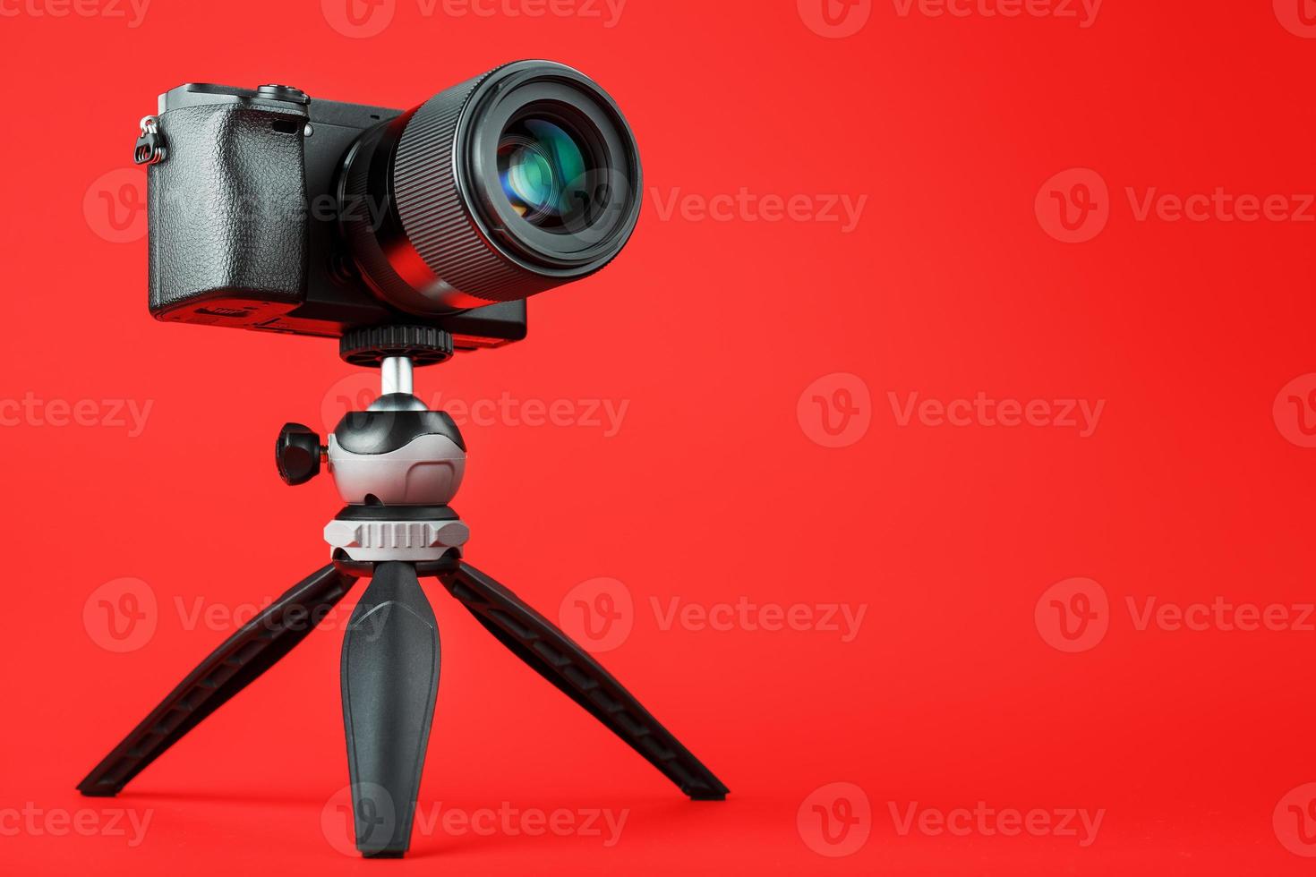 Professional camera on a tripod, on a red background. Record videos and photos for your blog, reportage