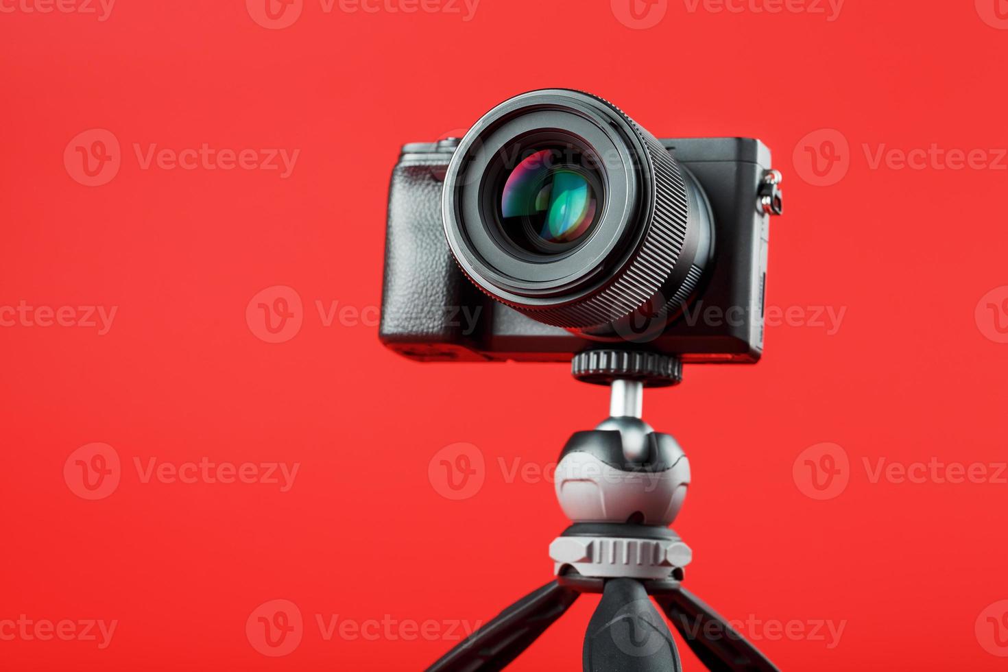 Professional camera on a tripod, on a red background. Record videos and photos for your blog, reportage