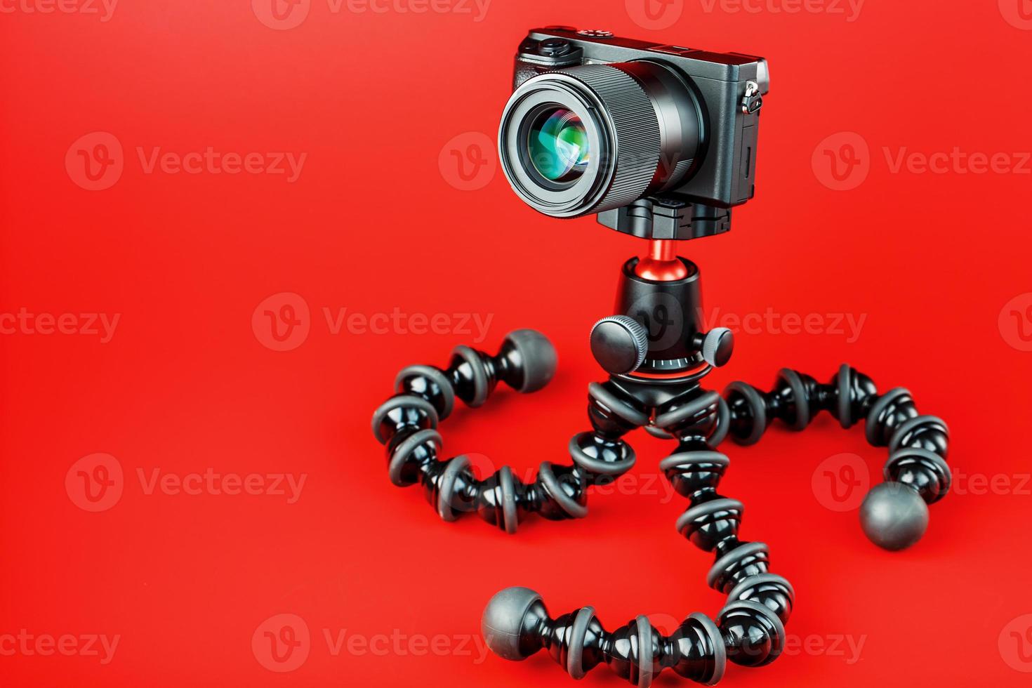 Professional camera on a tripod, on a red background. Record videos and photos for your blog, reportage