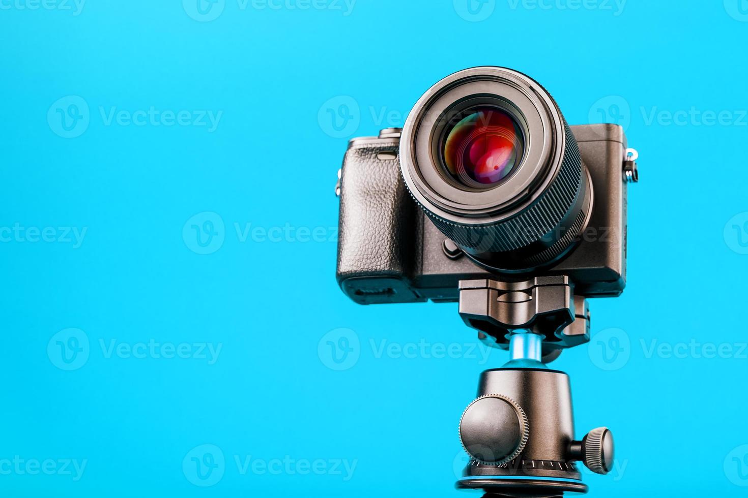 Professional camera on a tripod, on a blue background. Record videos and photos for your blog or report.