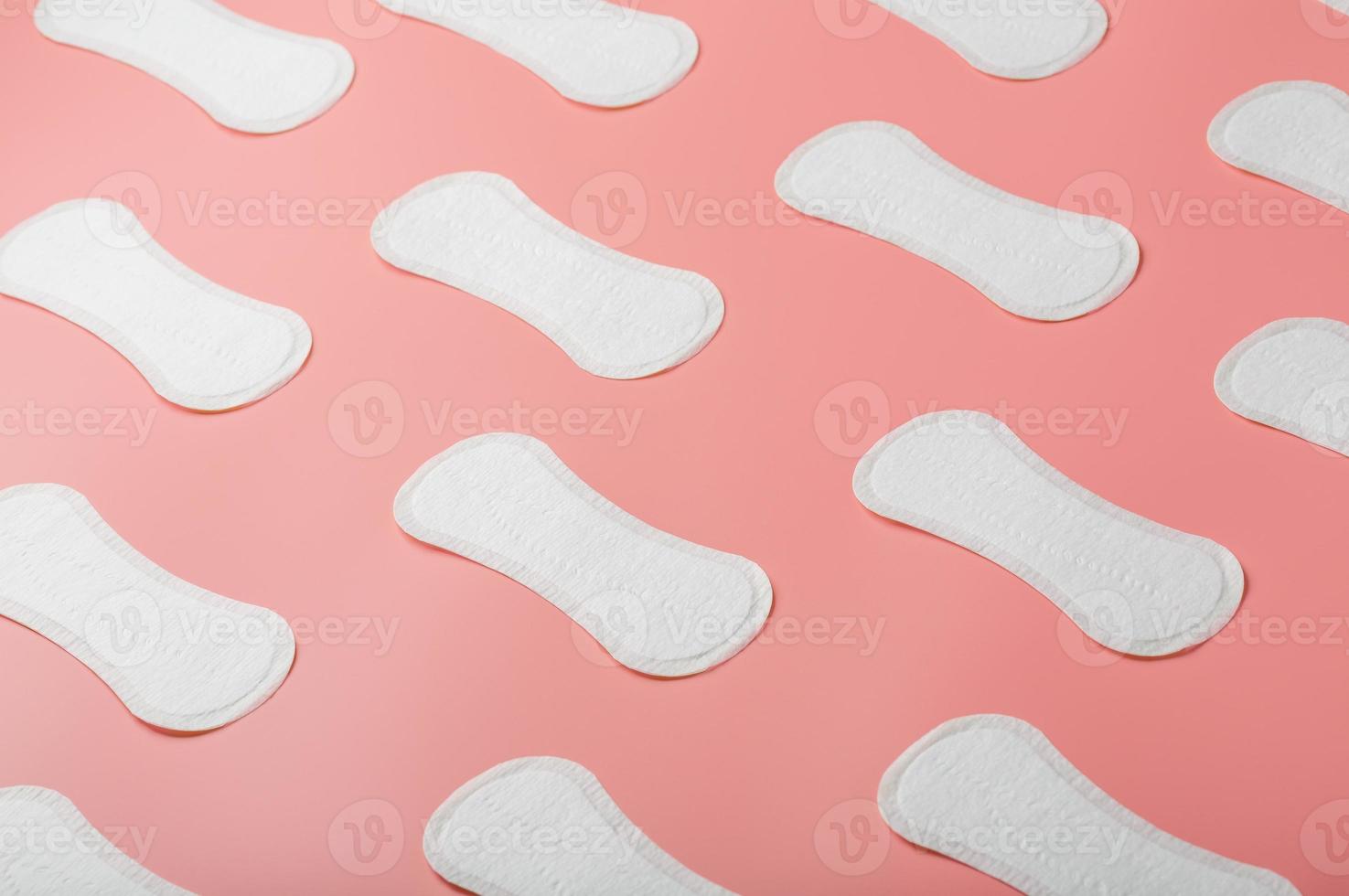 Sanitary pad on a pink background in the form of a diagonal pattern. Textured background over the entire screen. photo