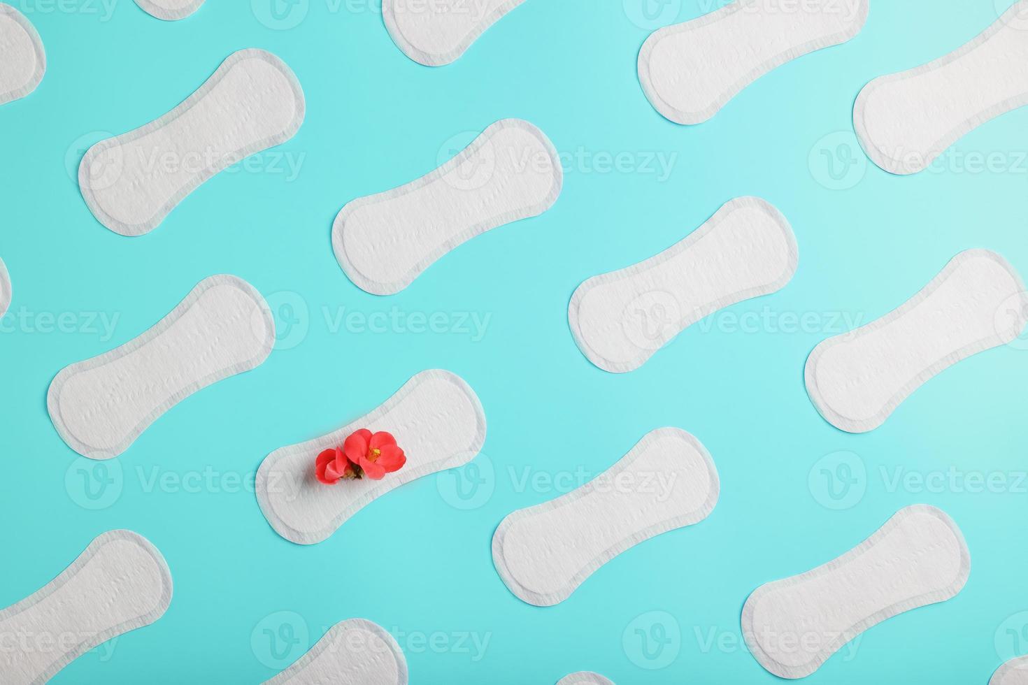 Many Sanitary pads on a blue background in the form of a diagonal pattern with a flower. Textured background all over the screen. photo