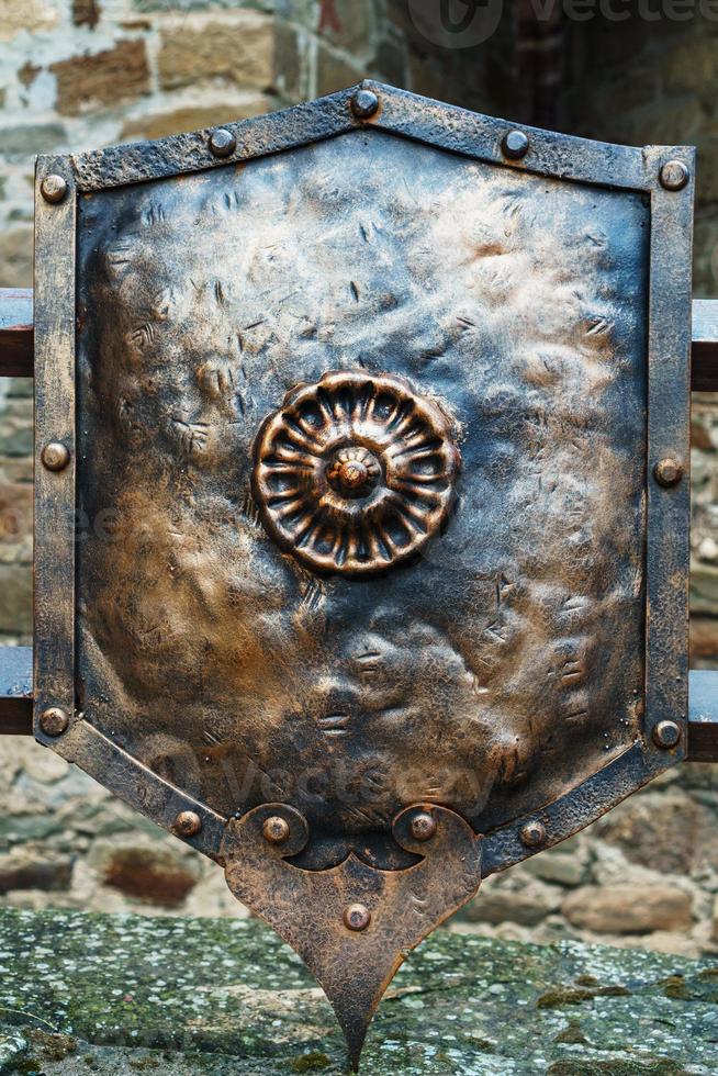 Medieval antique metal shield, with a textured surface. photo