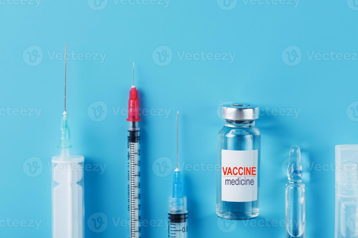 medicamentos con ampolla de vacuna de jeringa sobre un fondo azul. foto