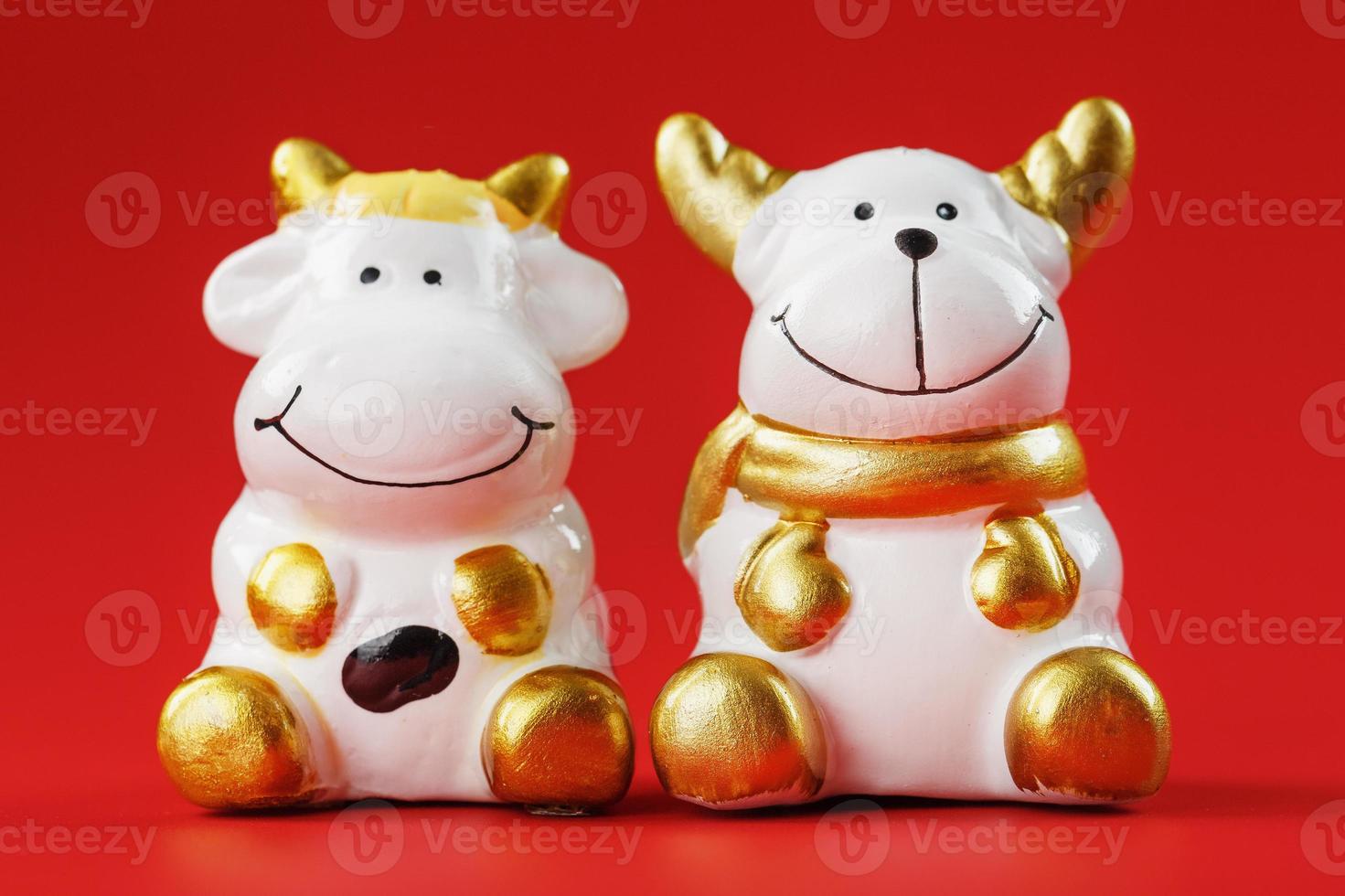 A pair of cow and bull Figures on a red background, with free space. photo