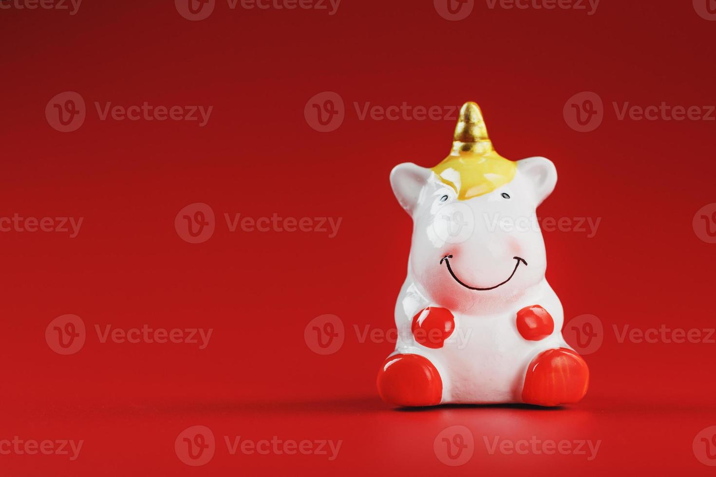 Small figure of a unicorn on a red background. The concept of magic, children's dreams photo