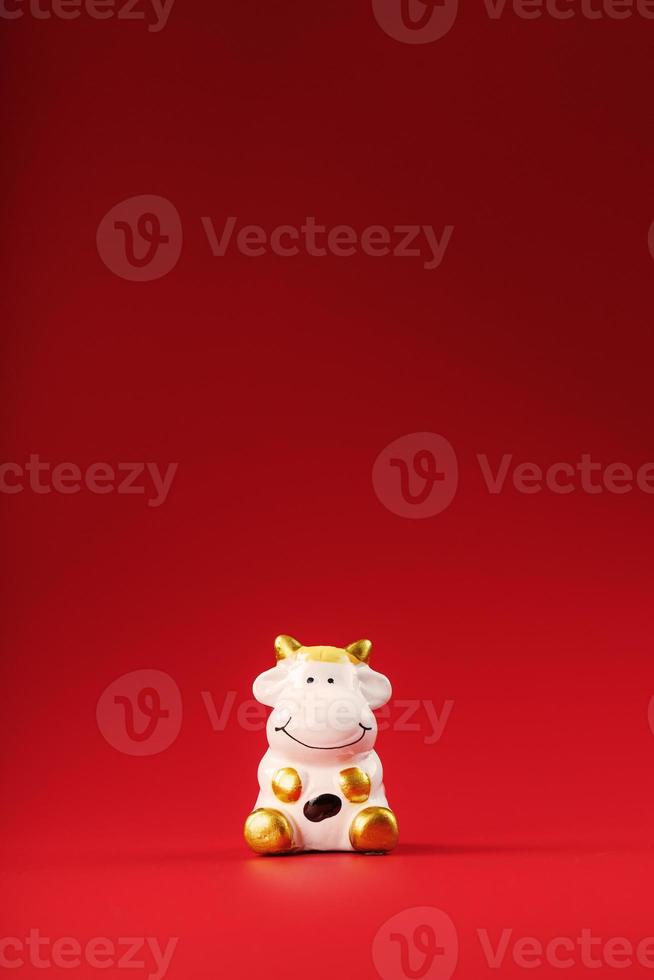 Figurine of a cow from on a red background, free space for text. photo