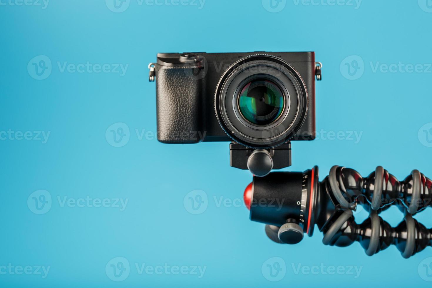 cámara en un trípode, sobre un fondo azul. grabar videos y fotos para su blog o informe.