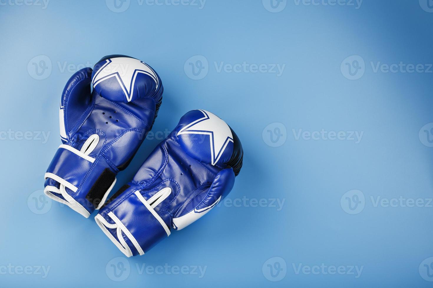 un par de guantes de boxeo de cuero sobre un fondo azul, espacio libre. foto