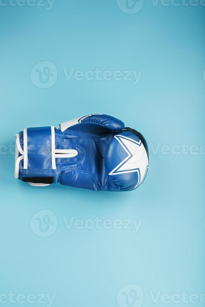 Blue Boxing glove on a blue background, free space. photo