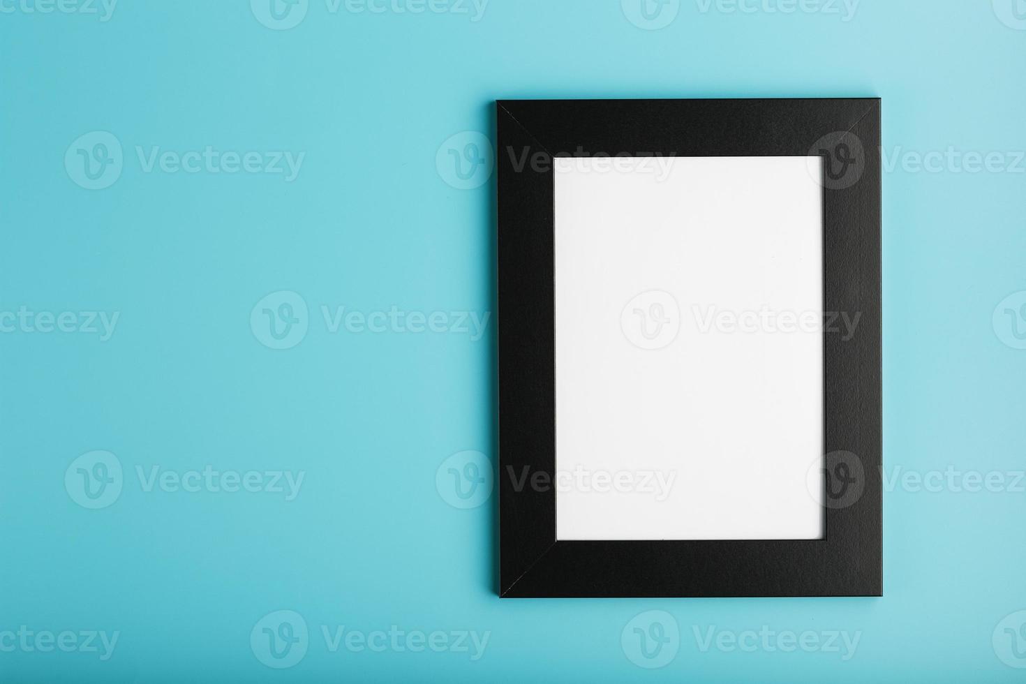 Black photo frame with empty space on a blue background.