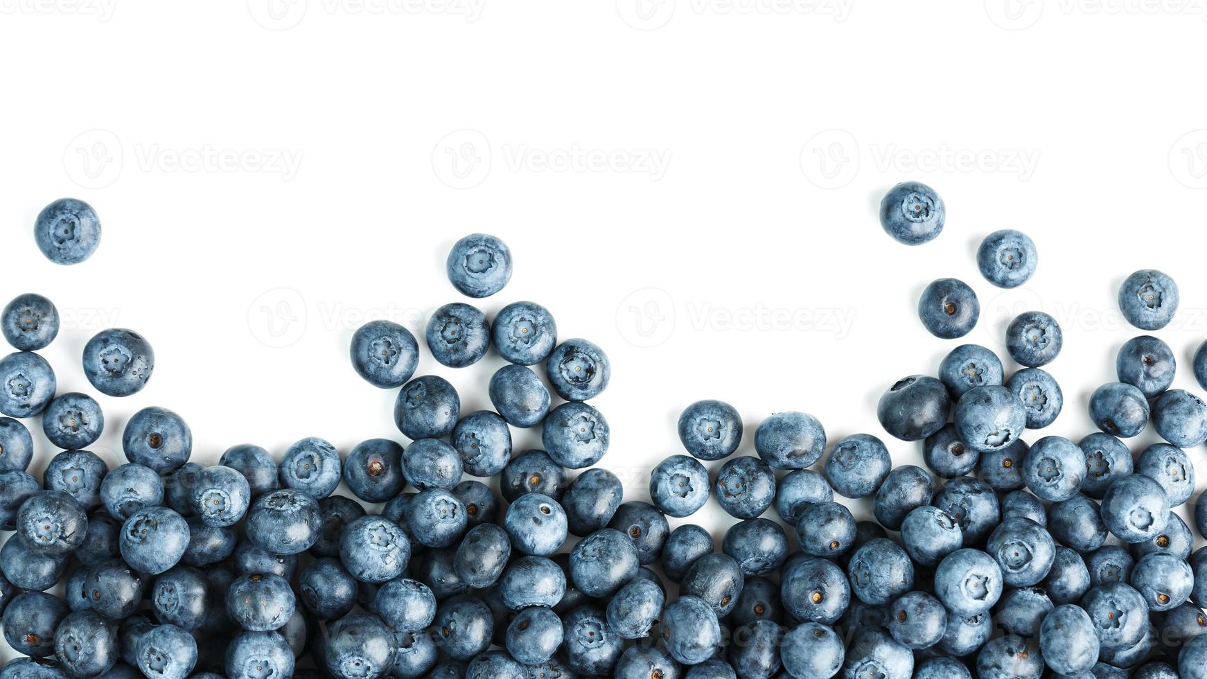 Tasty blueberries fruit are scattered on a white background. Frame photo