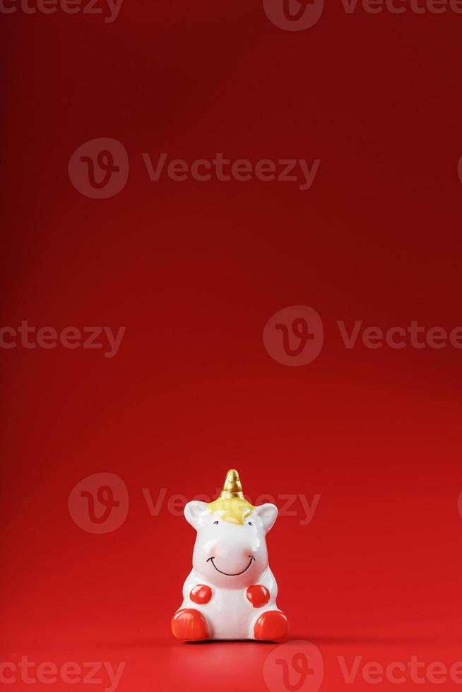 Unicorn figurine on a red background with free space. photo