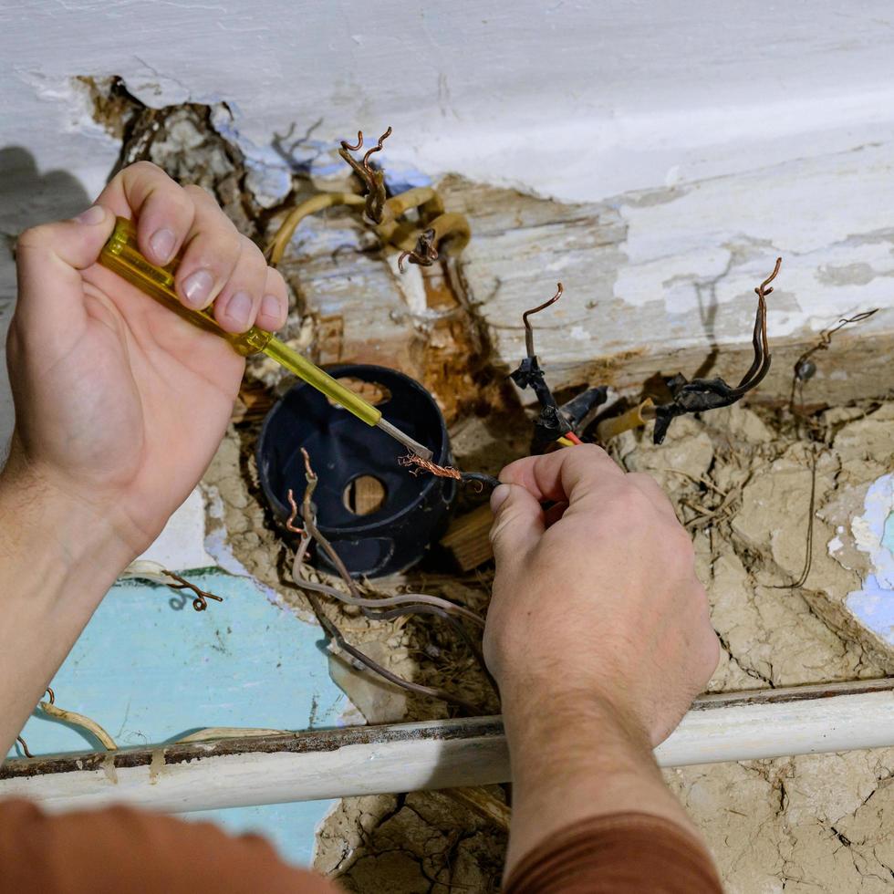 Old electrical wiring in the house, wooden walls in the house, replacement of electrical cables. photo