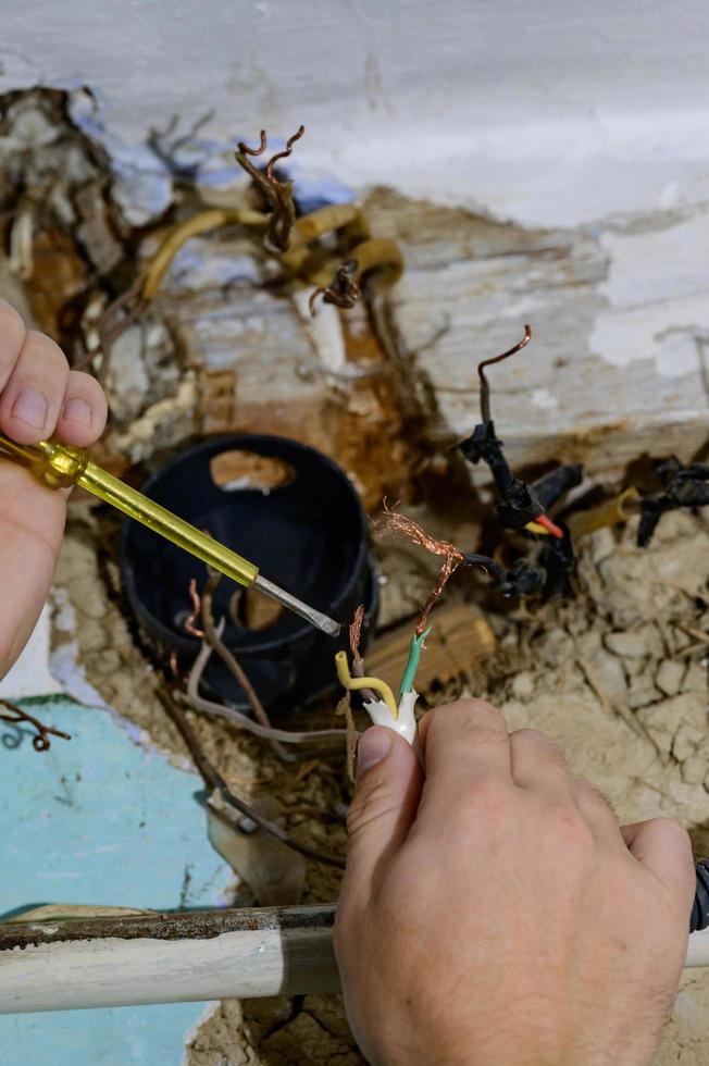 Old electrical wiring in the house, wooden walls in the house, replacement of electrical cables. photo