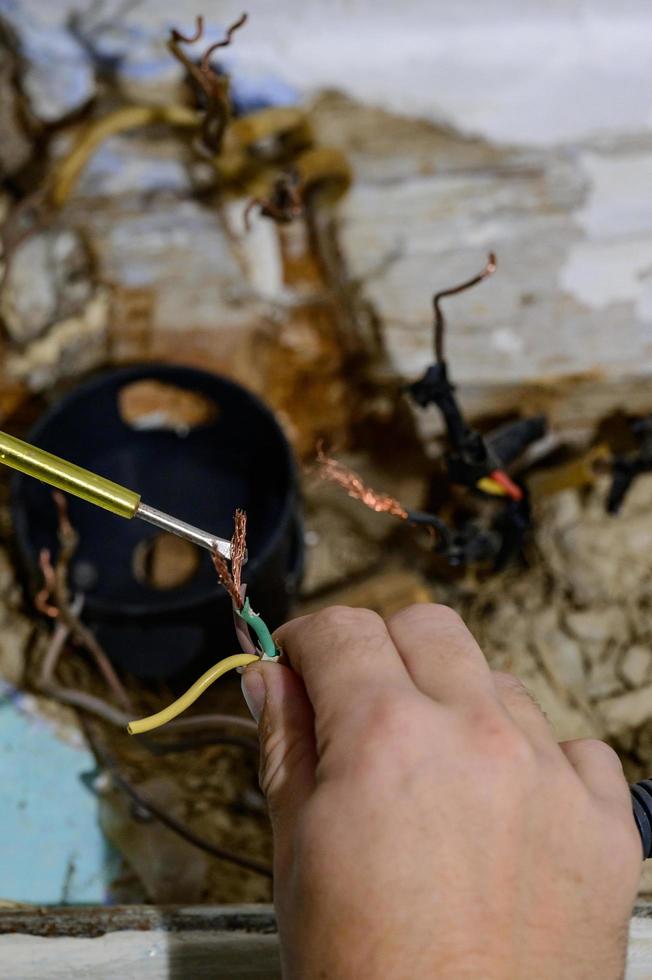 Old electrical wiring in the house, wooden walls in the house, replacement of electrical cables. photo