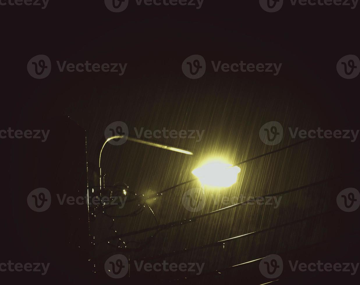 lloviendo noche y luz. gotas de lluvia cayendo en la noche en bangkok, tailandia, en la temporada de lluvias de agosto. foto