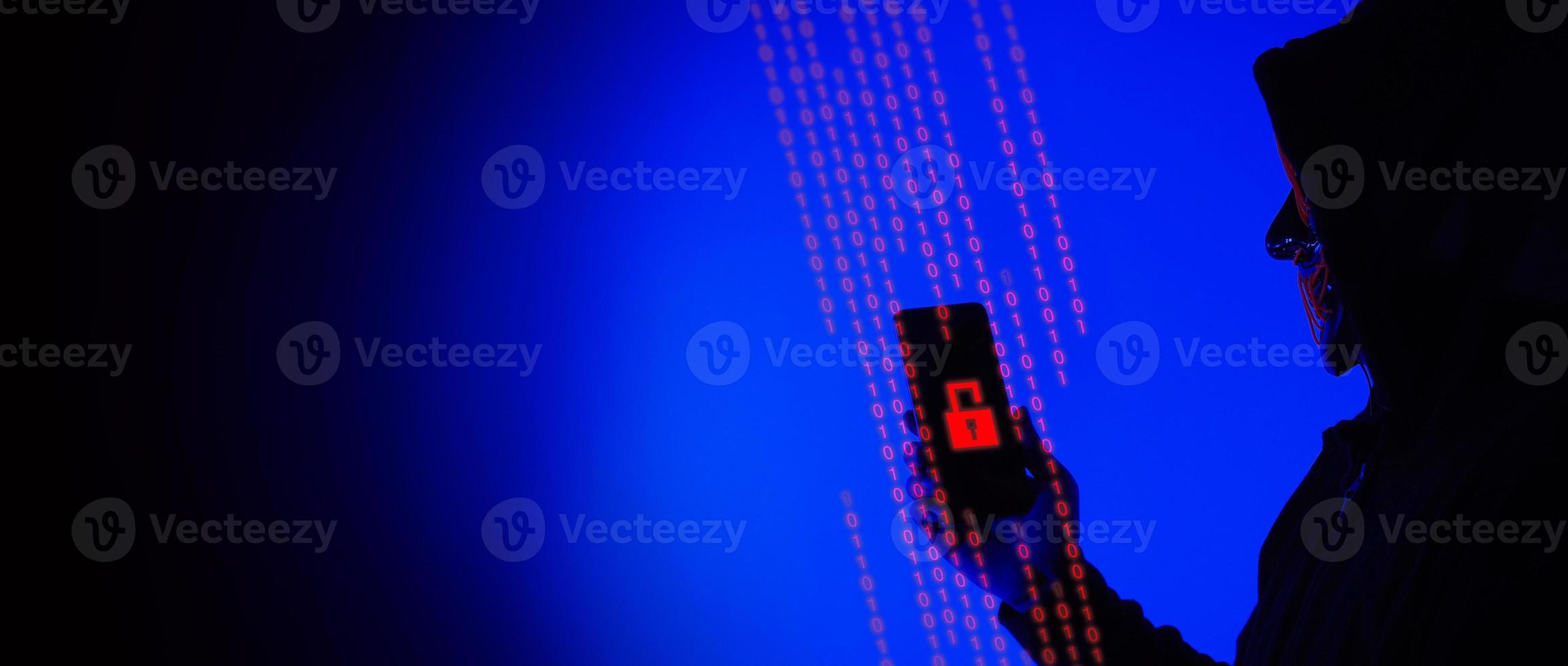 Digital security Concept. Anonymous hacker with mask holding smartphone hacked. photo