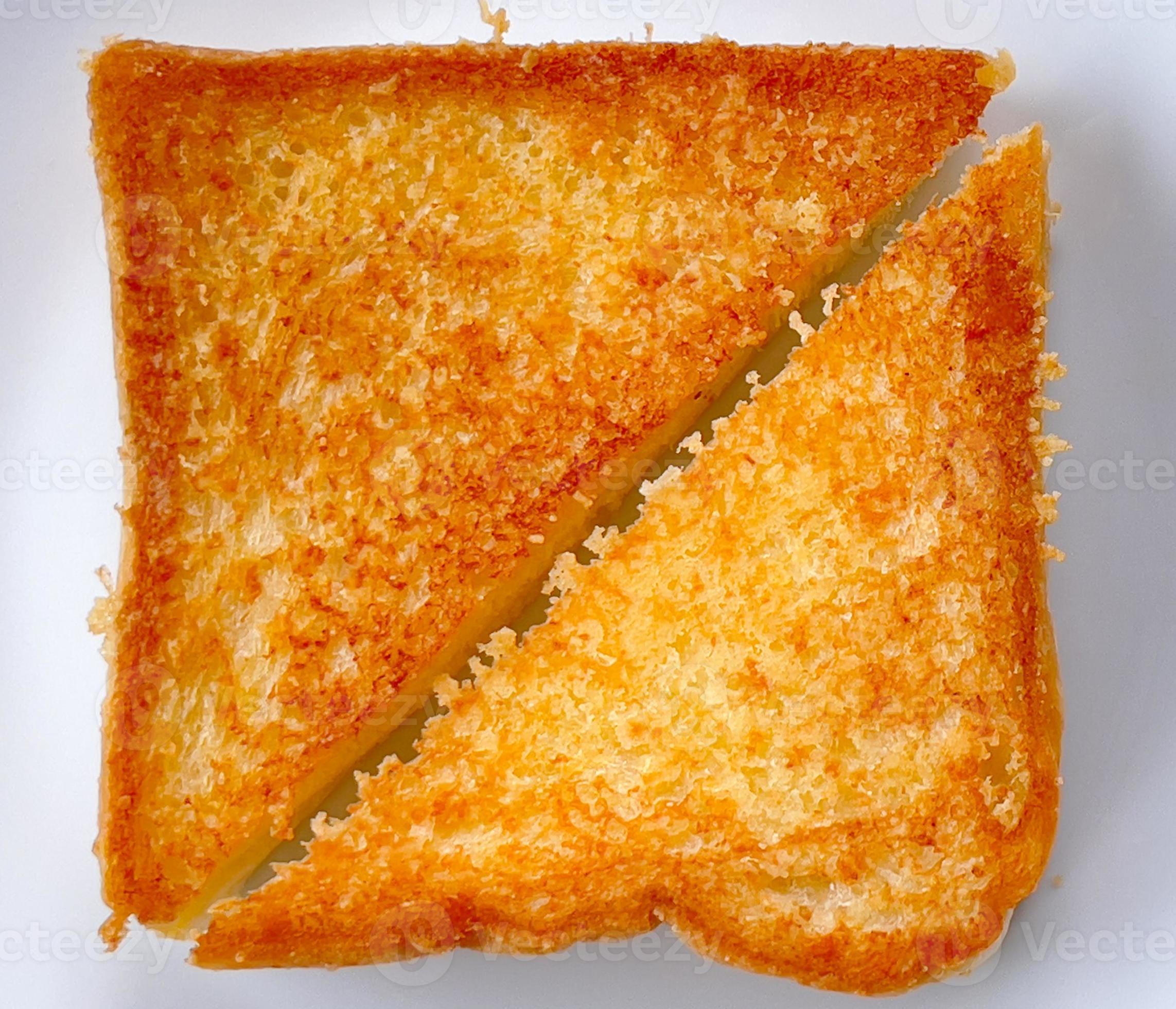Two piece triangle slices of toasted bread made from white wheat flour and a slice of cheddar