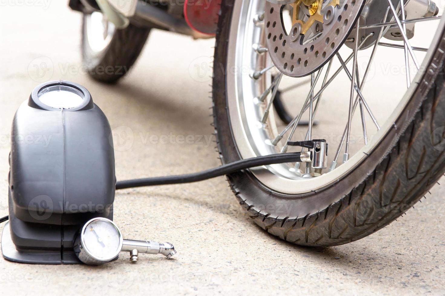 inflator pressure of the tires with motorcycle with electric pump on road basic maintenance photo