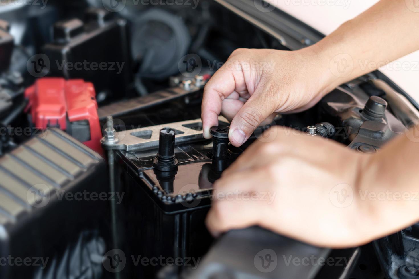 A man open cap of add battery for add distilled , maintenance and inspections for extended service life battery of car photo