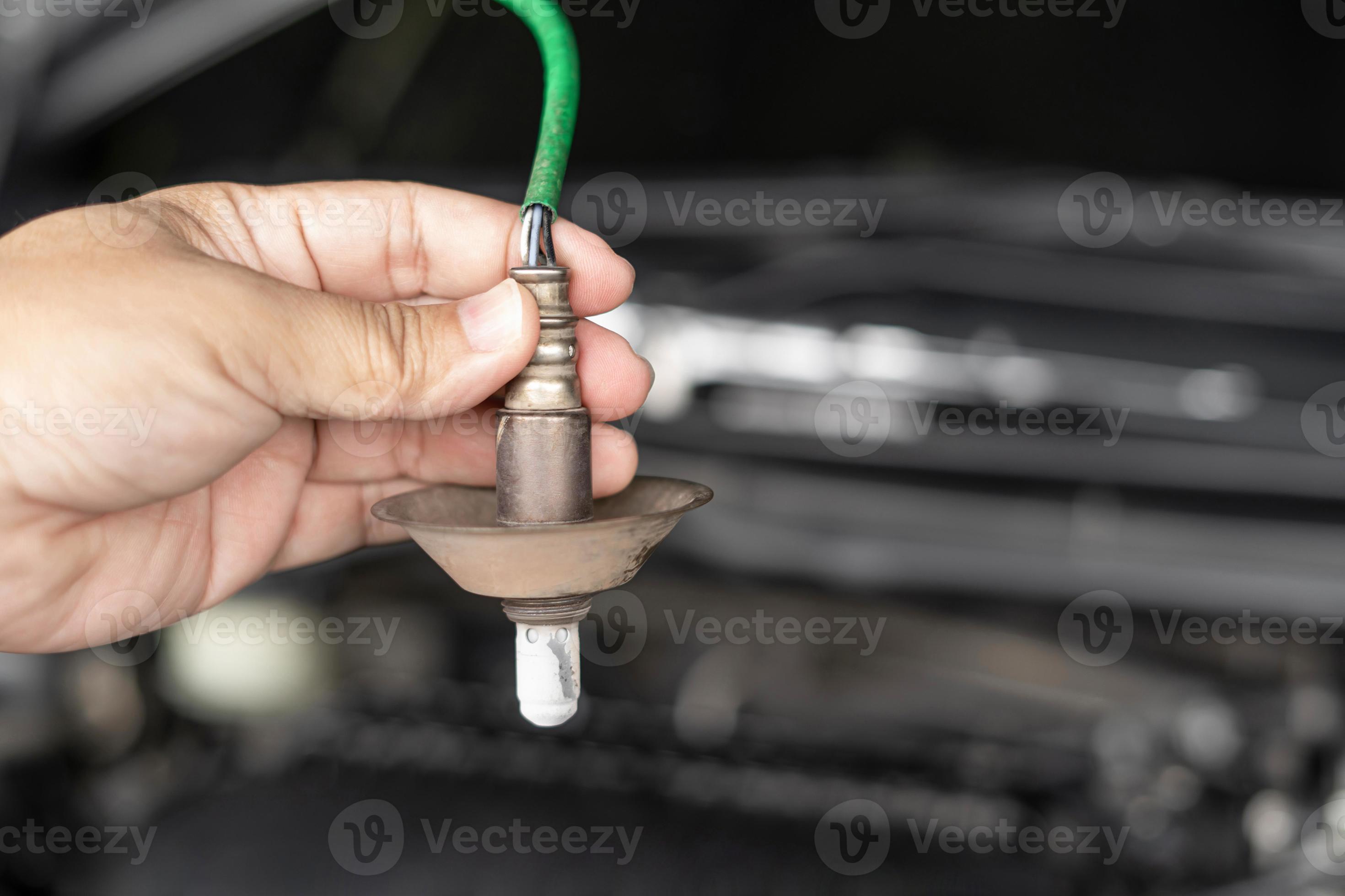 Close up hand car mechanic hold oxygen sensor of exhaust system of